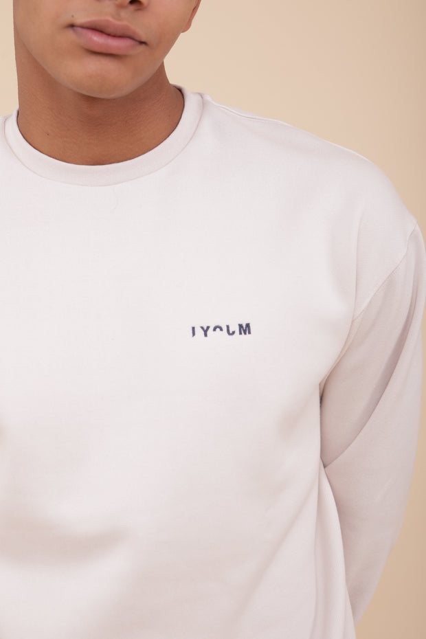 Zoom sur le logo LYOUM, sur sweat écru.