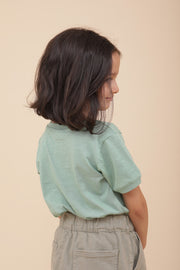 Petite fille de dos avec son nouveau tshirt LYOUM.
