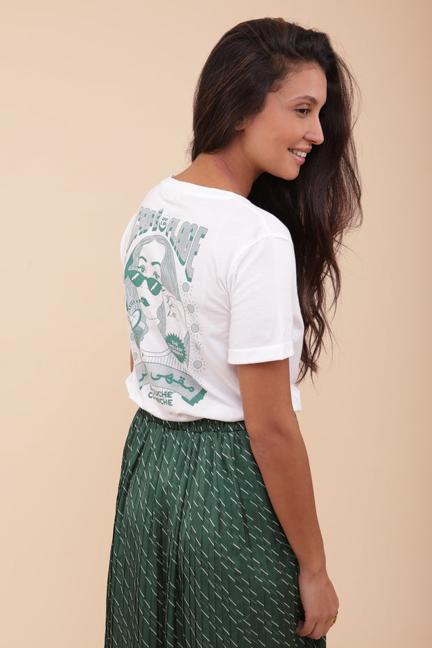 Femme portant le tshirt blanc 'Café de la Plage' : The chillest in Beirut' imprimé au dos en Vert foncé. Avec un petit LYOUM en hiéroglyphe brodé au coeur.