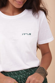 Femme portant le tshirt blanc avec un petit LYOUM en hiéroglyphe brodé au coeur.