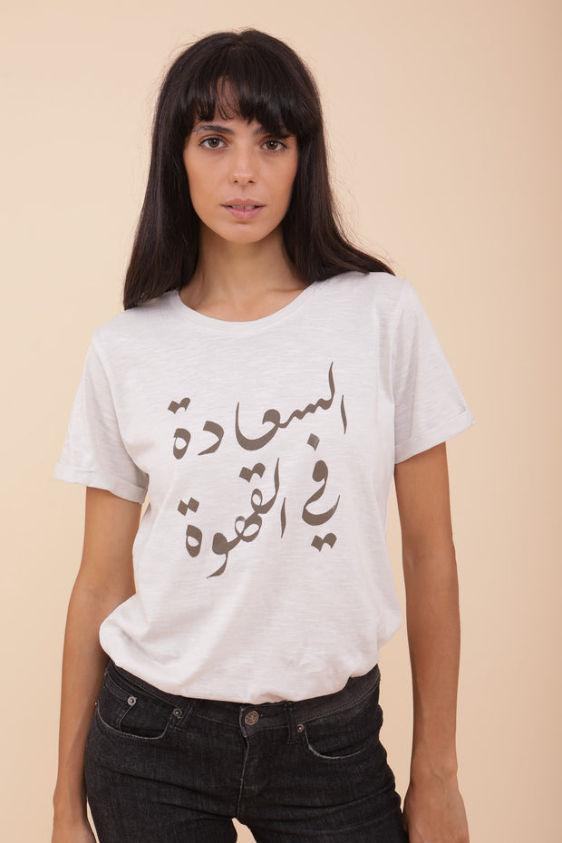 Femme portant le tshirt écru grisé 'Es-saâda fel Kahwa' : 'Le Bonheur est dans le Café' en arabe.