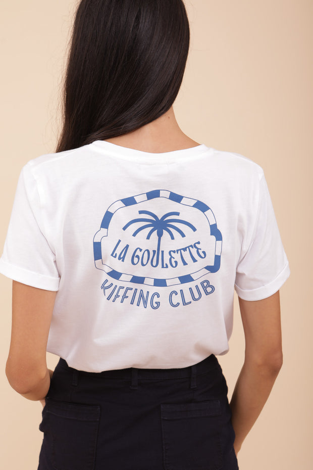 Femme de dos, portant le tshirt blanc 'La Goulette' - 'Kiffing Club' imprimé en bleu.