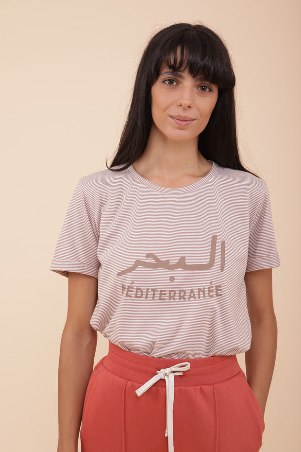Femme portant le tshirt 'La Mer Méditerranée' avec un pantalon en molleton.