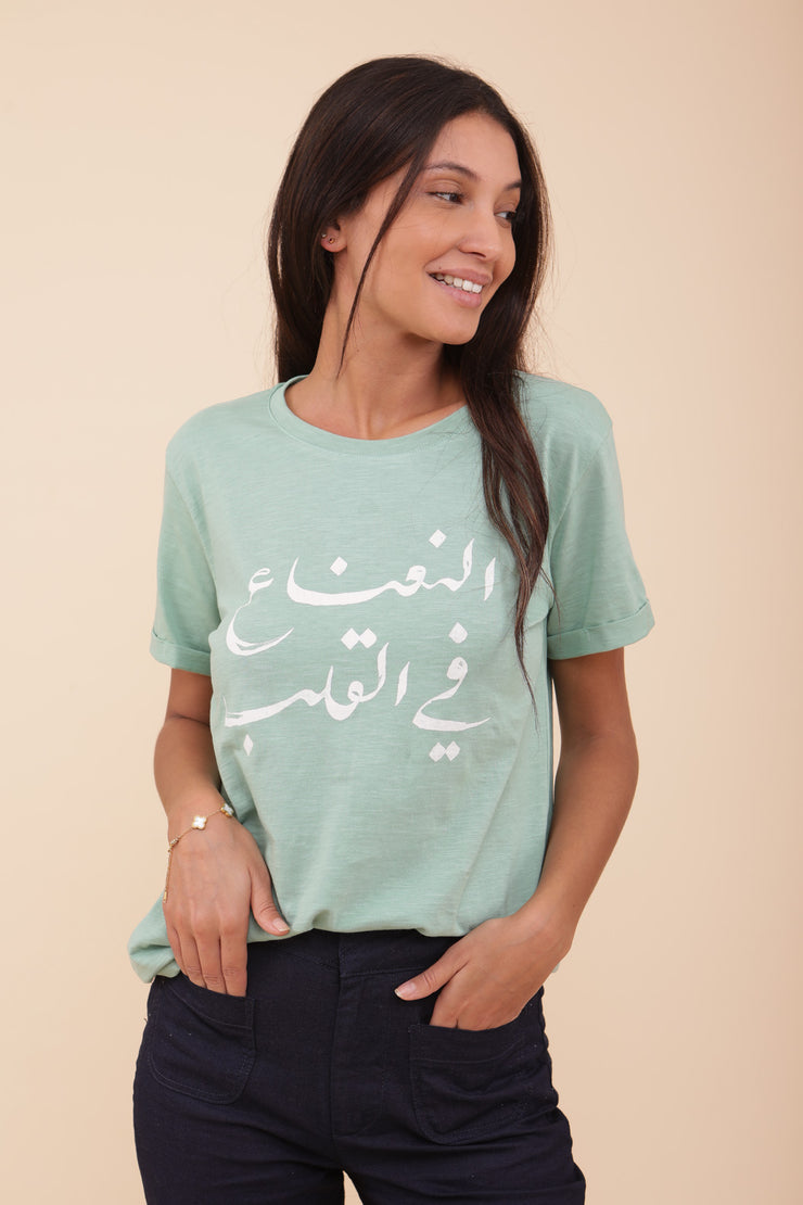 Femme portant le tshirt vert clair 'La menthe dans le cœur' en arabe sérigraphiée.