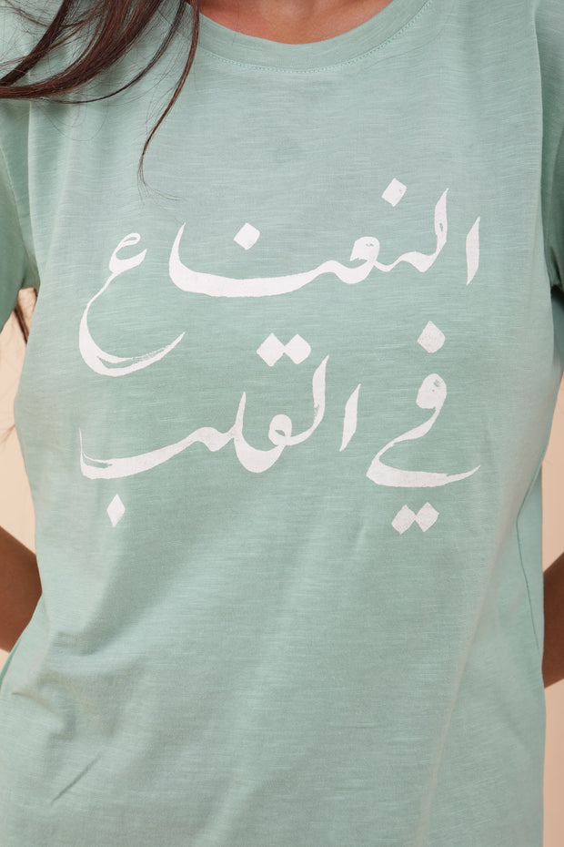 Zoom in sur le tshirt 'La menthe dans le cœur' en arabe sérigraphiée.