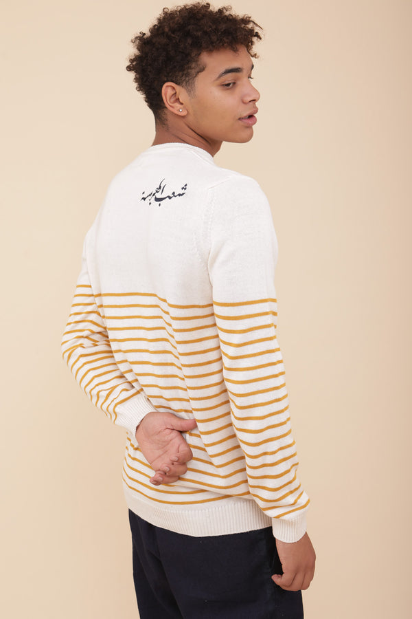 Homme en pull LYOUM à rayures jaune et calligraphie.