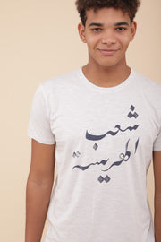 Il porte notre t-shirt écru grisé : 'Harissa People' en Arabe