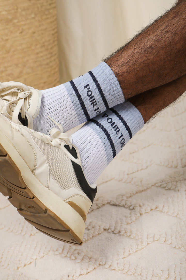 Chaussettes LYOUM blanches et message Couscous Pour Tous en bleu.