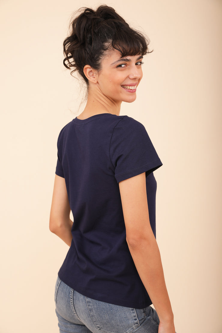 Vue de dos d'une femme souriante portant le tshirt LYOUM bleu.