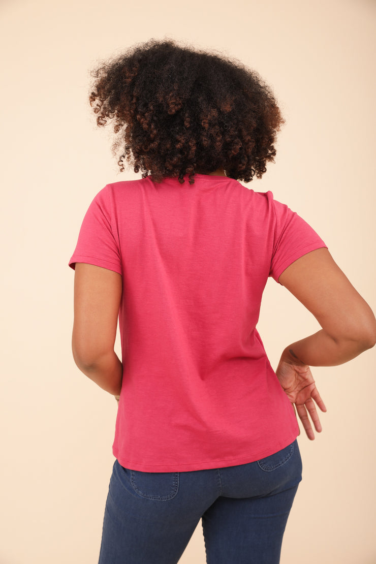 Vue dos d'une femme frisée en t-shirt LYOUM rose.