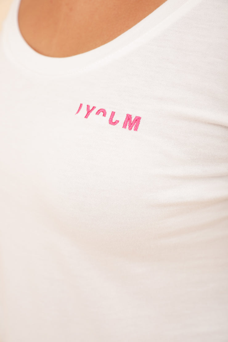 Zoom sur le petit LYOUM rose, sur tshirt blanc.