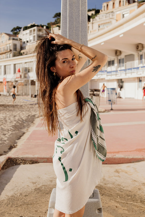 Femme à la plage avec sa serviette fouta LYOUM en paréo.