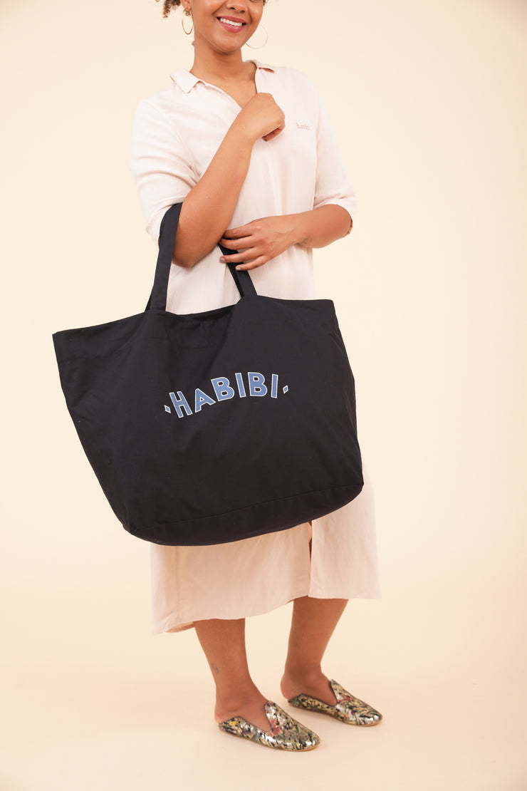 Femme portant à la main le sac de plage LYOUM Habibi.
