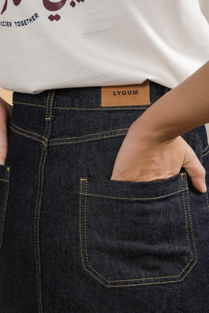 Zoom sur la poche arrière et l'étiquette de la jupe LYOUM en denim.