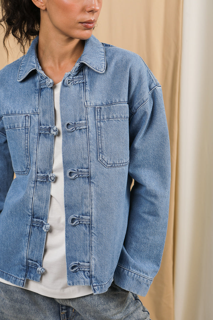 Détails de la veste dengri LYOUM en denim délavé.
