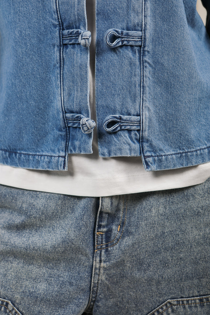 Détails de la veste LYOUM en denim avec boutons chinois.