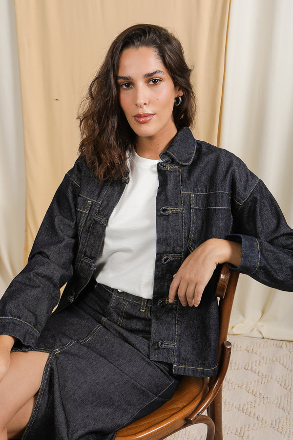 Femme en ensemble LYOUM Denim assise sur une chaise.