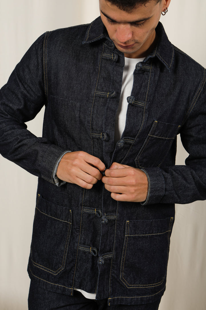 Homme qui boutonne sa veste LYOUM en denim foncé.