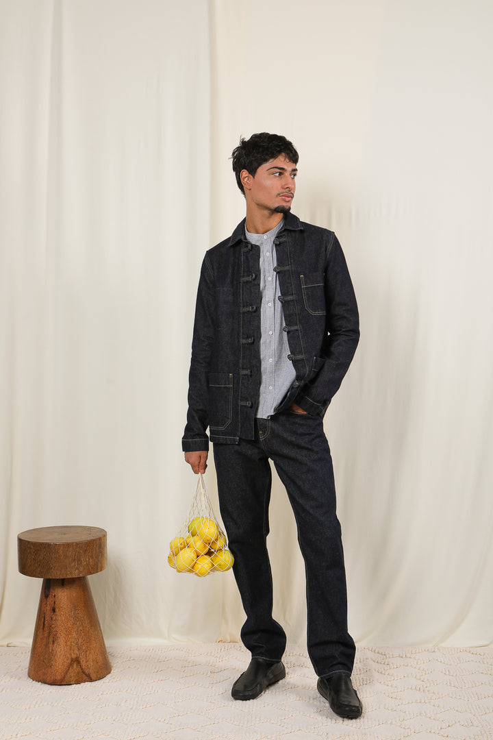 Homme en tenue complète denim, portant un panier avec des citrons.