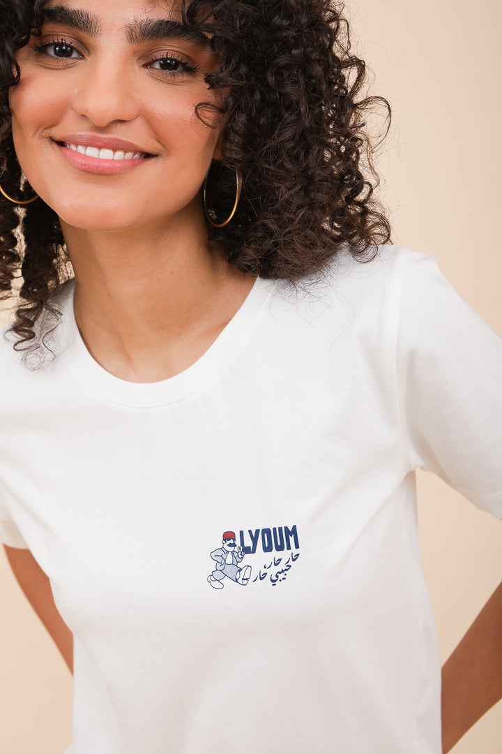 Femme brune en tshirt blanc avec dessins et mots LYOUM au coeur.