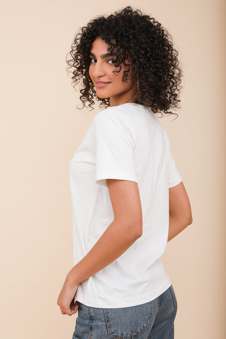 Femme typée méditerranéenne de profil en tshirt blanc.