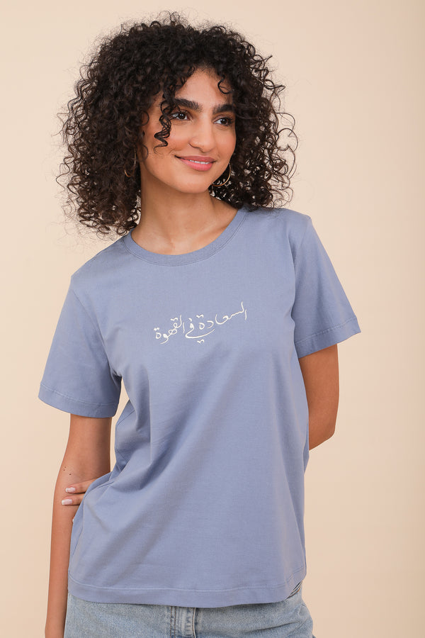 Femme brune en tshirt bleu avec calligraphie arabe LYOUM.