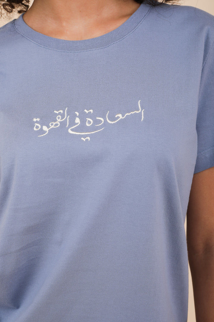 Calligraphie arabe LYOUM sur tshirt bleu.