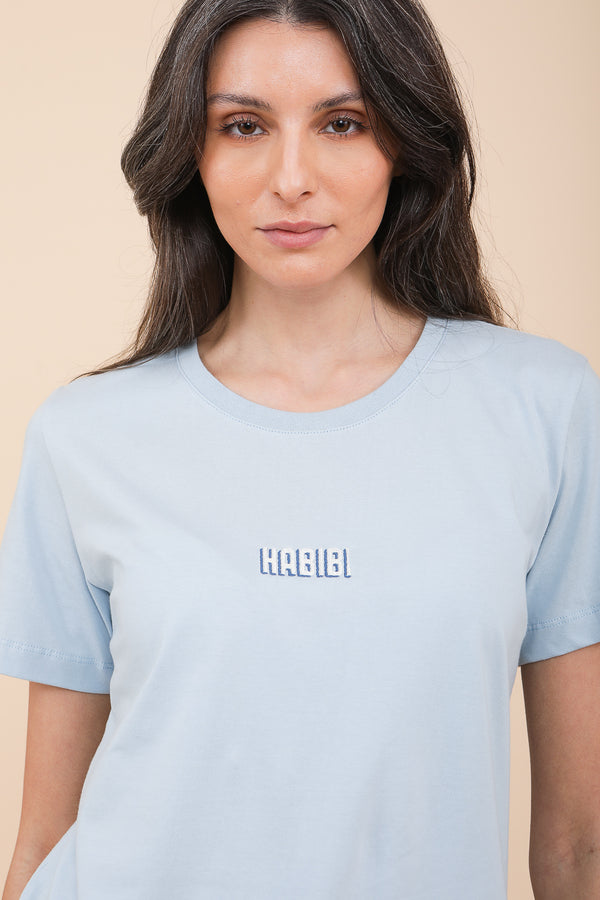 Femme brune en tshirt LYOUM bleu habibi.