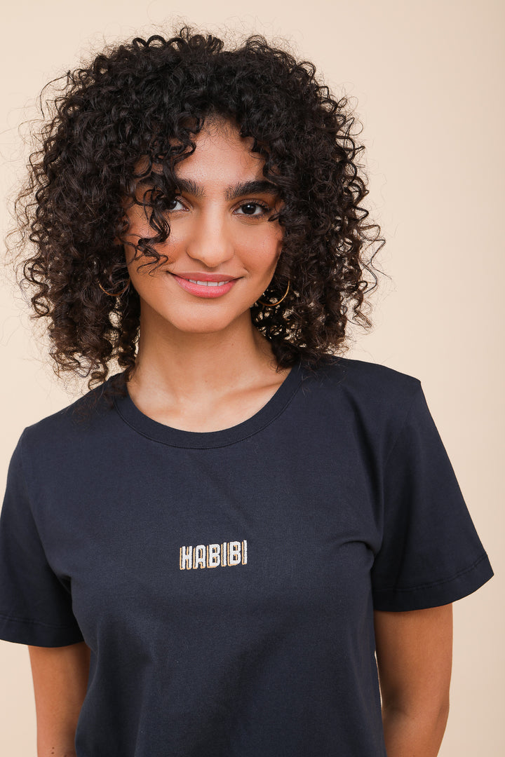 Femme aux cheveux bouclées en tshirt LYOUM Habibi.