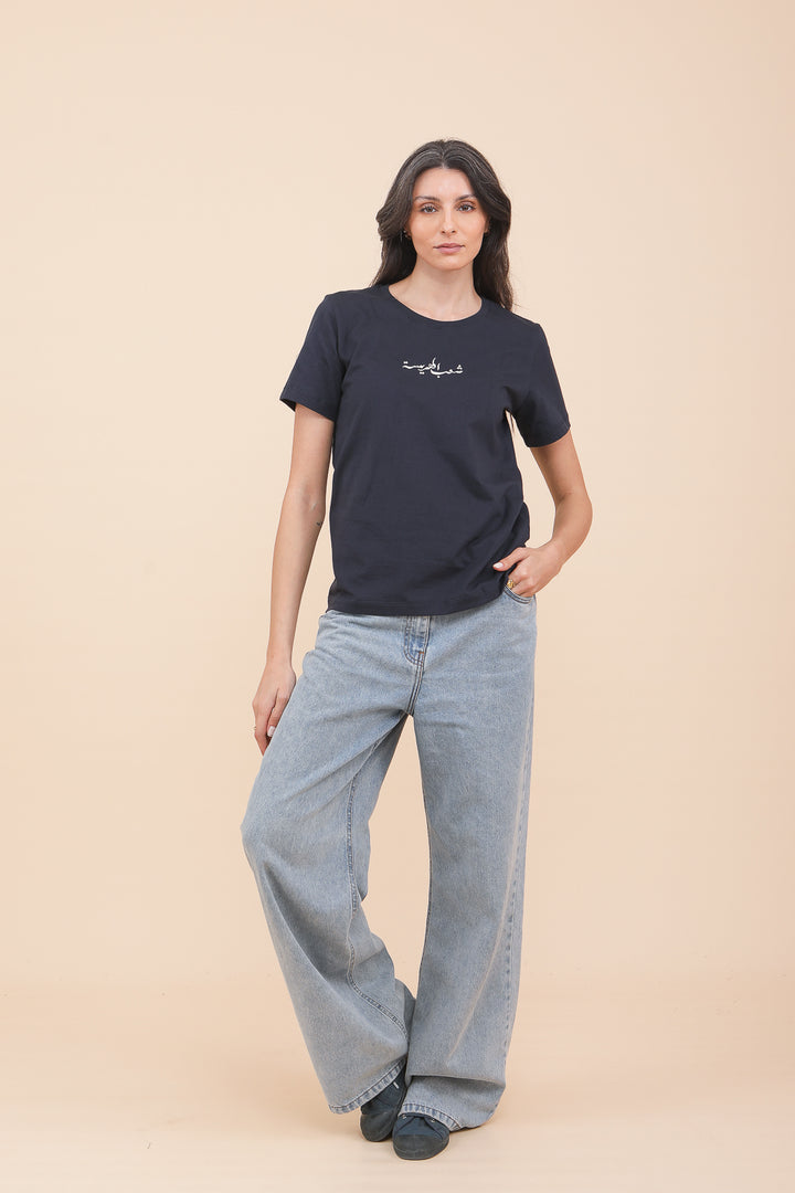 Silhouette d'une femme brune en tshirt LYOUM bleu navy et jeans.