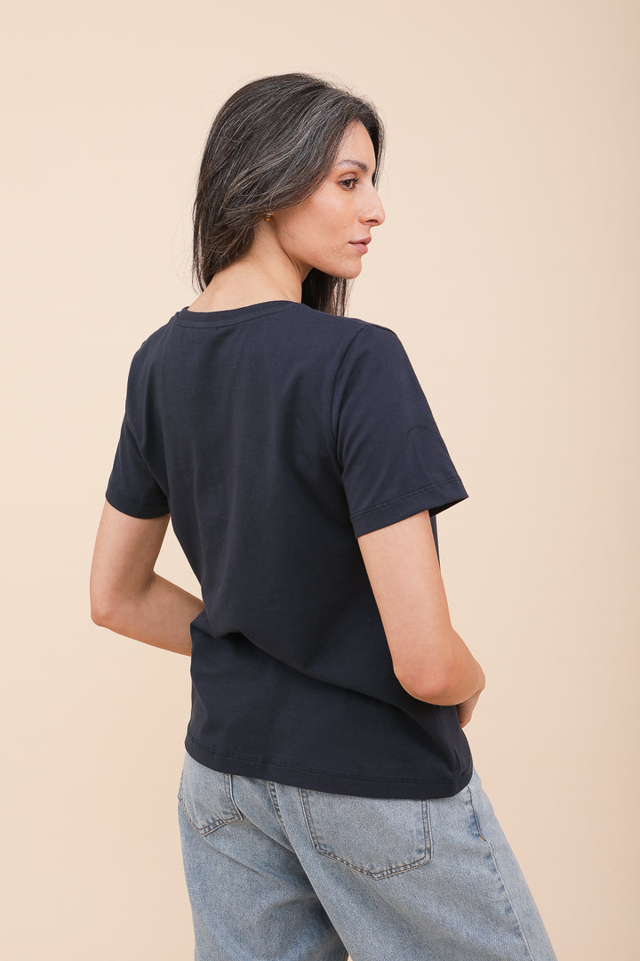 Vue dos d'une femme brune en tshirt LYOUM bleu navy.