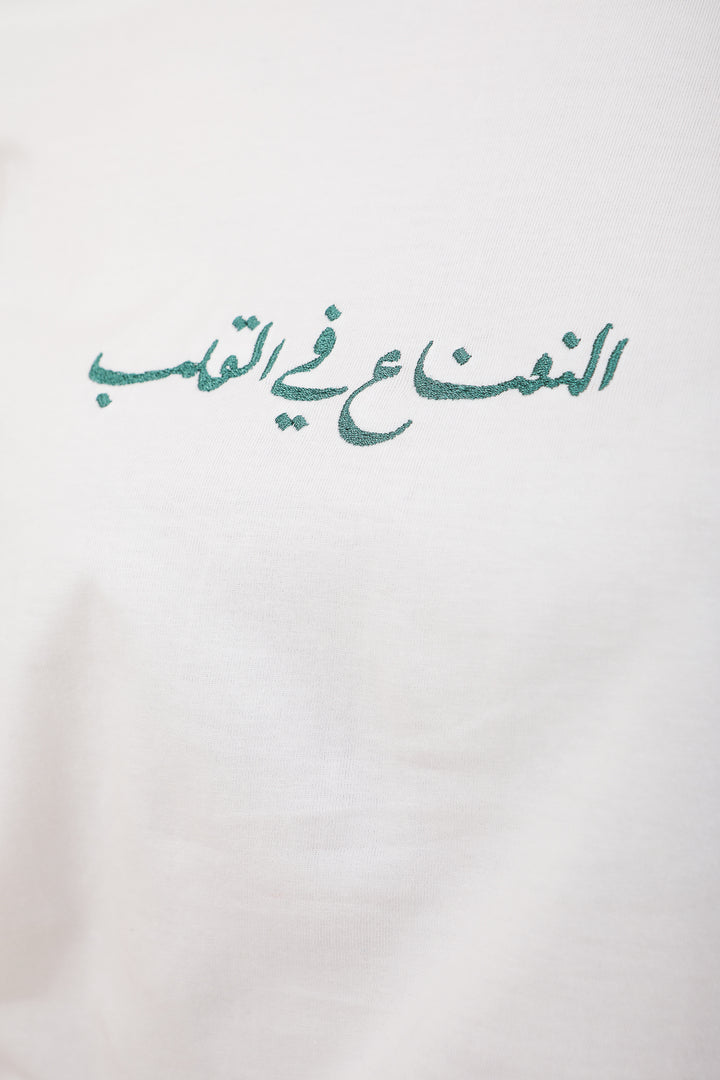 Calligraphie LYOUM verte brodée sur tshirt blanc.