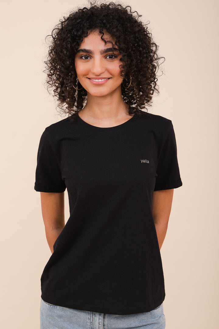 Femme bouclée souriante en tshirt LYOUM noir.