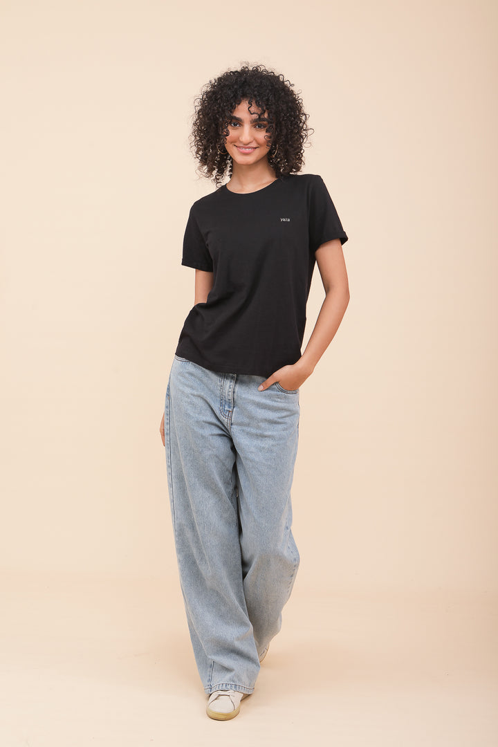 Silhouette de femme brune en tshirt LYOUM noir et jeans.