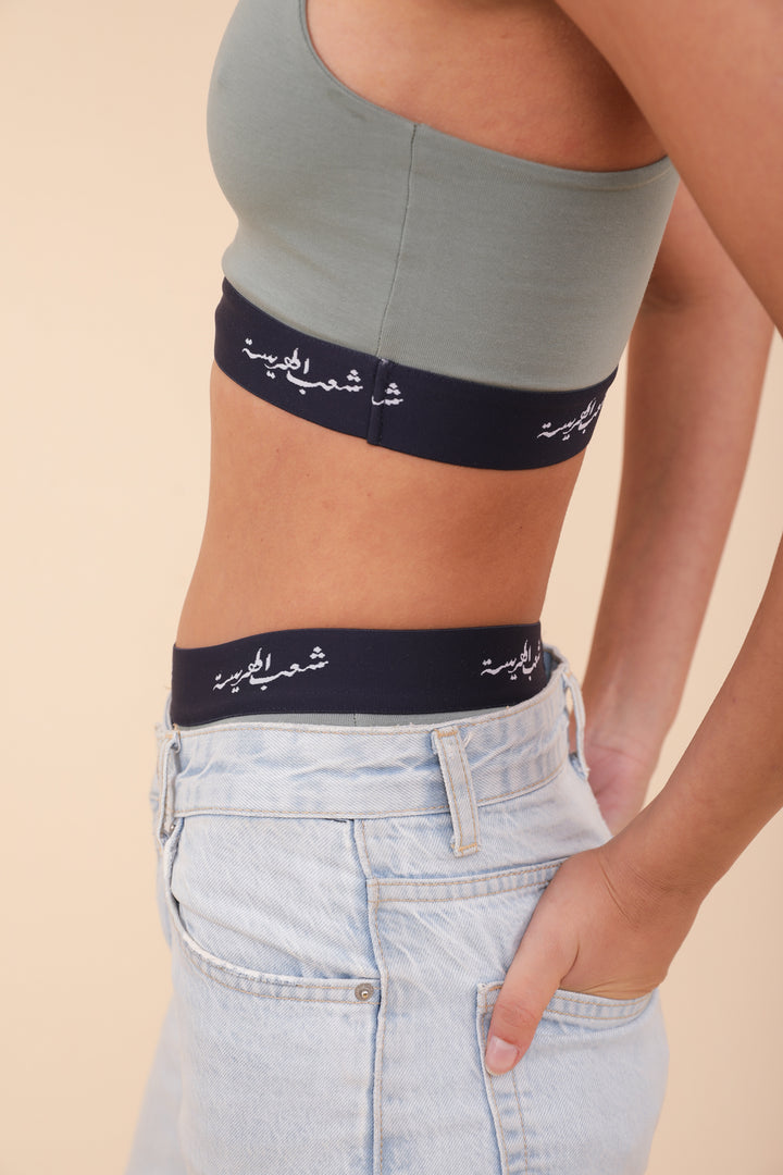 Vue profil de la brassière LYOUM et élastique de la culotte dépassant du jeans.