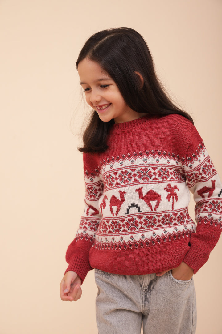 Enfant souriant en pull de Noël LYOUM rouge.