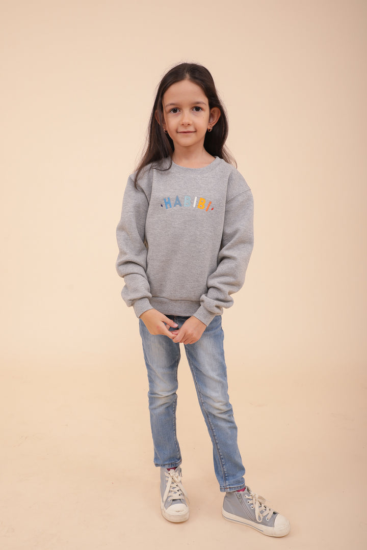 Enfant en jean et sweat LYOUM gris.