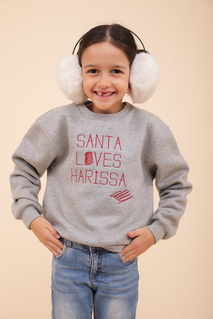 Enfant souriant portant un cache-oreilles et sweat santa LYOUM.