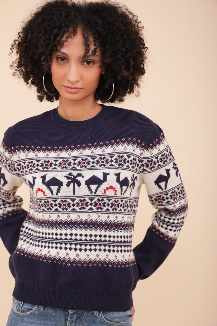 Femme aux cheveux bouclés et pull de Noël LYOUM bleu.