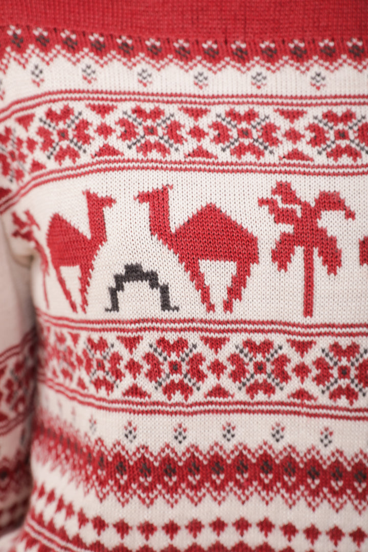 Zoom sur le motif dromadaires et palmiers du Pull de Noël LYOUM rouge.