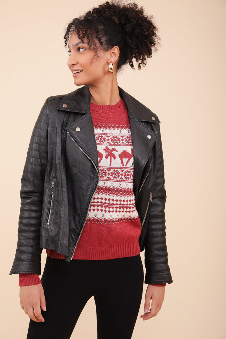 Femme en Pull de Noël LYOUM et veste en cuir courte.