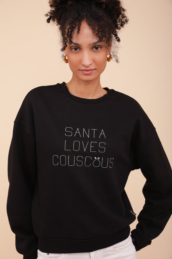 Femme en sweat noir LYOUM à message Santa Loves Couscous.