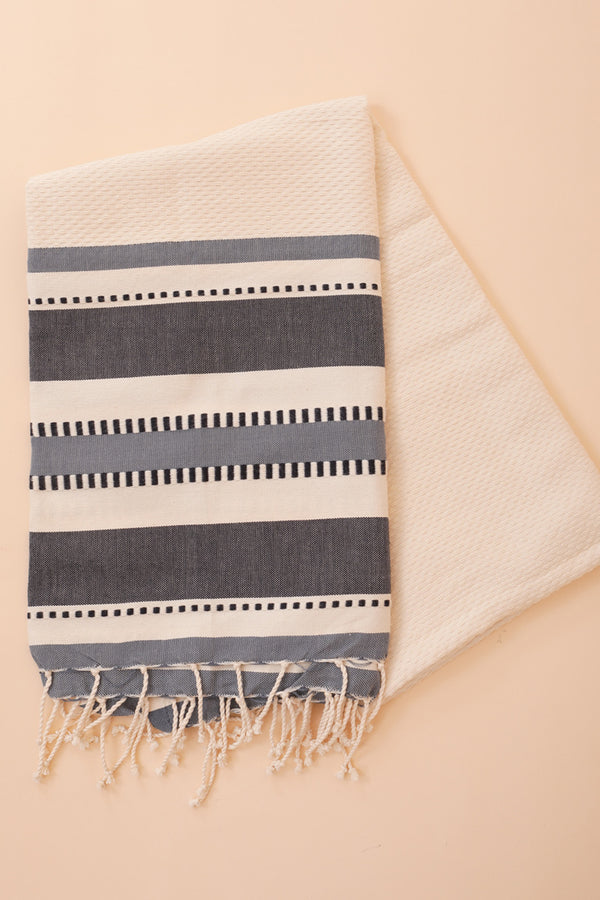 Découvrez la Fouta LYOUM, au tissage nid d'abeille en 100% coton à rayures bleu/blanc, ultra douce et très absorbante. L'accessoire idéal pour tous les amoureux de la plage.