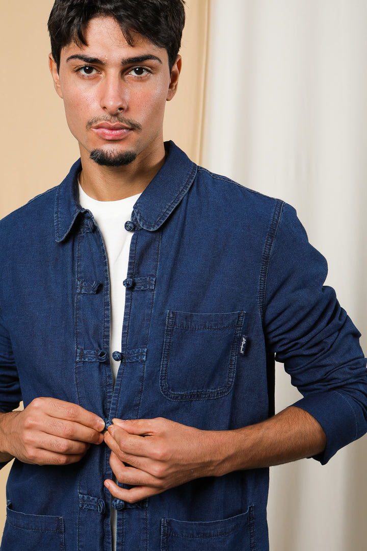 Homme boutonnant sa veste légère en jeans.