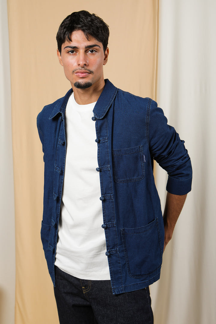 Homme en veste LYOUM en jeans, les mains derrière le dos.