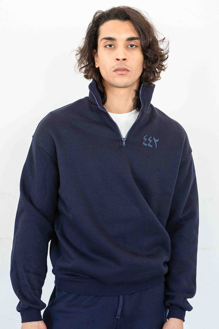 Homme en sweat LYOUM bleu et chiffres arabes brodés au coeur.