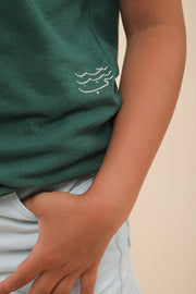 Polo LYOUM pour enfant, coupe unisexe pour un confort optimal. Col et bas de manches en bord-côtes avec trois boutons sur le devant. Broderie Habibi sur le côté, en calligraphie arabe. Photo zoom sur le message.
