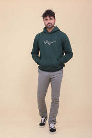 Pièce iconique, le hoodie pour homme by LYOUM, en molleton épais et gratté, de couleur vert sapin. Coupe parfaite. Broderie 'Le Bonheur est dans le Café' en calligraphie arabe sur le devant.