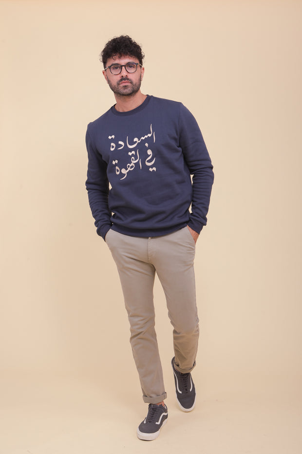 Pièce iconique, le sweat pour homme by LYOUM, en molleton épais et gratté, de couleur bleu navy. Une coupe classique et indémodable, manches longues et col rond. Belle calligraphie 'Le Bonheur est dans le Café' en arabe sur le devant.