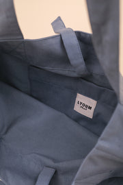 Tote Bag en toile, avec poche et anses intérieures, couleur bleu clair. Broderie 'Habibi' ('Mon Amour' en arabe) sur un côté en fil écru.